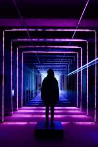 silhouette photo of person standing in neon lit hallway